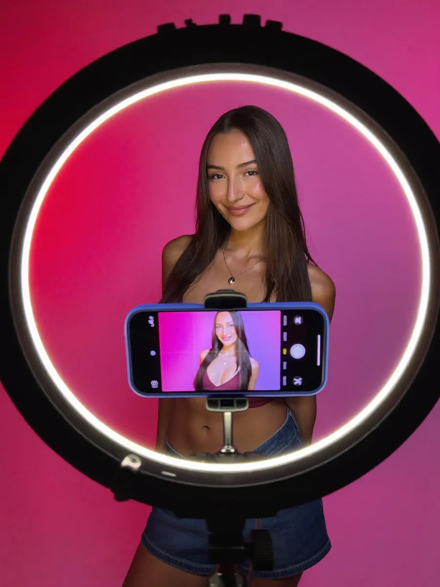 Creatorin filmt sich mit dem Smartphone vor einem Ringlicht